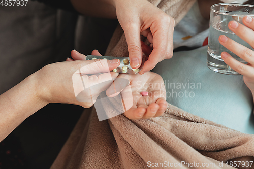 Image of Close up shoot of mother giving pills for little daughter feeling sick with coronavirus symptopms in mild condition