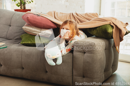 Image of Little girl in protective mask isolated at home with coronavirus symptoms, stop epidemic