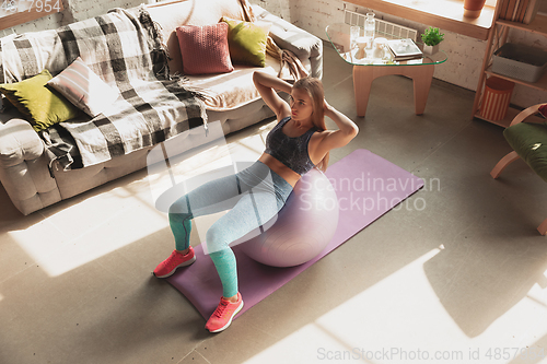 Image of Young woman teaching at home online courses of fitness, aerobic, sporty lifestyle while being quarantine