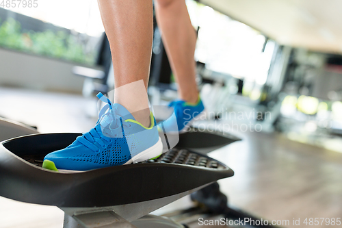 Image of Sport woman working out on elliptical trainer in gym