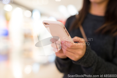 Image of Woman using cellphone for online