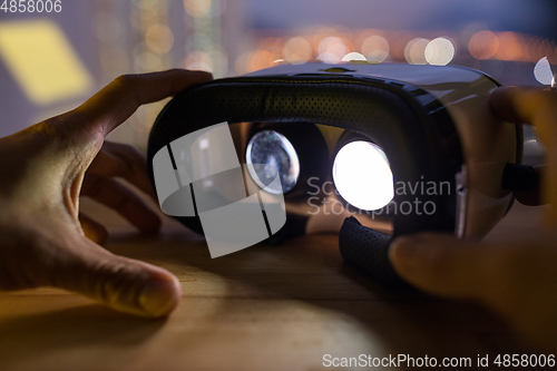Image of Male hand holding VR device at night