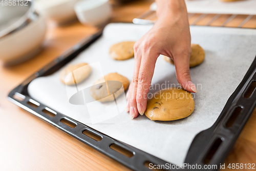 Image of Woman putting paste on metal tray