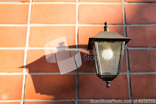 Image of Street lamp over red brick wall