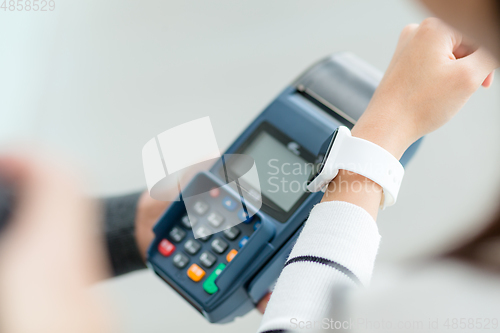 Image of Woman using smart watch to pay