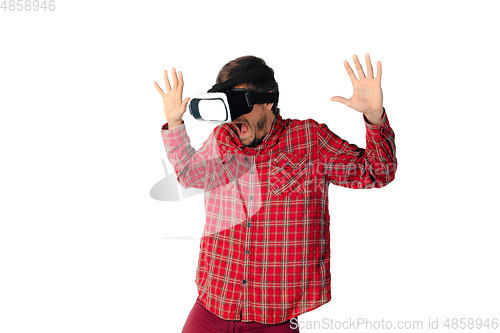 Image of Man emotional playing, using virtual reality headset isolated on white studio background