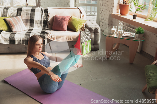 Image of Young woman teaching at home online courses of fitness, aerobic, sporty lifestyle while being quarantine