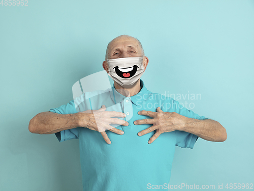 Image of Portrait of caucasian senior man with emotion on his protective face mask