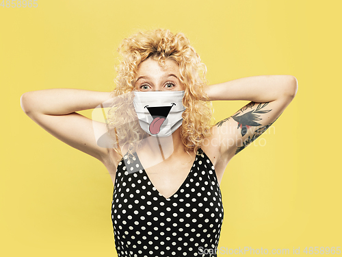 Image of Portrait of young caucasian woman with emotion on her protective face mask