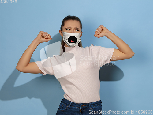 Image of Portrait of young caucasian girl with emotion on her protective face mask