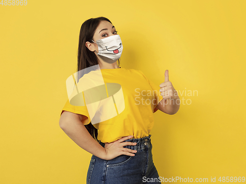 Image of Portrait of young caucasian woman with emotion on her protective face mask