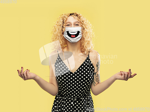 Image of Portrait of young caucasian woman with emotion on her protective face mask