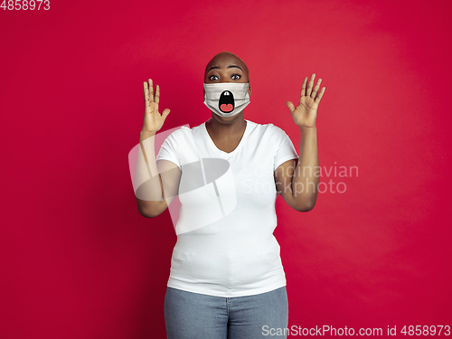 Image of Portrait of young african-american woman with emotion on her protective face mask