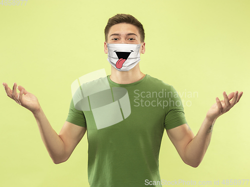 Image of Portrait of young caucasian man with emotion on his protective face mask