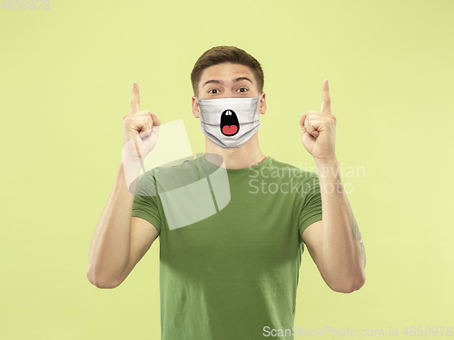 Image of Portrait of young caucasian man with emotion on his protective face mask