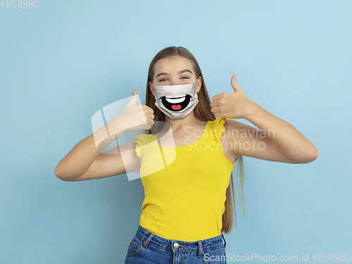 Image of Portrait of young caucasian girl with emotion on her protective face mask