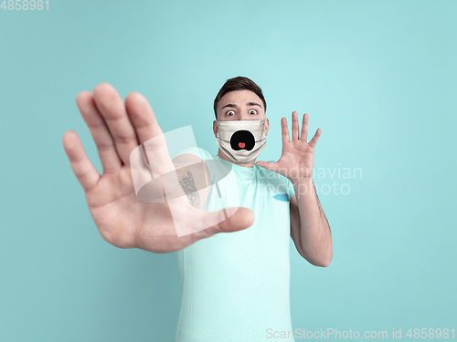 Image of Portrait of young caucasian man with emotion on his protective face mask