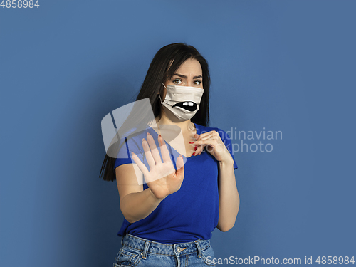 Image of Portrait of young caucasian woman with emotion on her protective face mask
