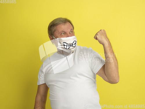 Image of Portrait of caucasian senior man with emotion on his protective face mask