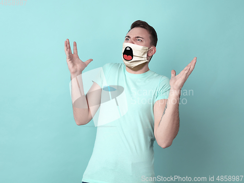 Image of Portrait of young caucasian man with emotion on his protective face mask