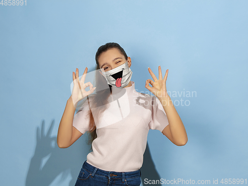 Image of Portrait of young caucasian girl with emotion on her protective face mask