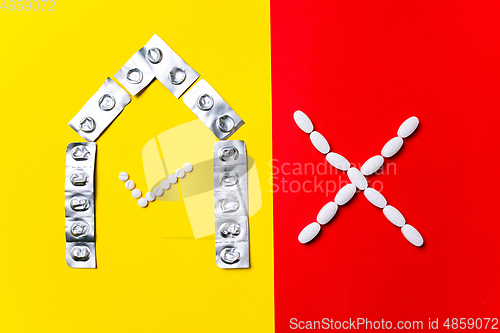 Image of Colored pills, tablets and capsules on a red and yellow background - history of treatment, prevention of pandemic