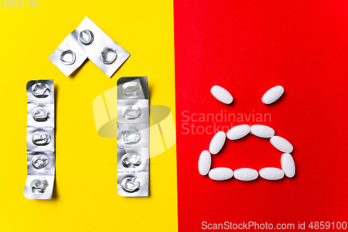 Image of Colored pills, tablets and capsules on a red and yellow background - history of treatment, prevention of pandemic