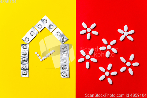 Image of Colored pills, tablets and capsules on a red and yellow background - history of treatment, prevention of pandemic