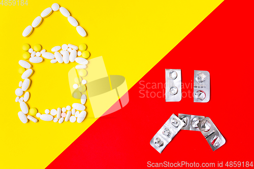 Image of Colored pills, tablets and capsules on a red and yellow background - history of treatment, prevention of pandemic