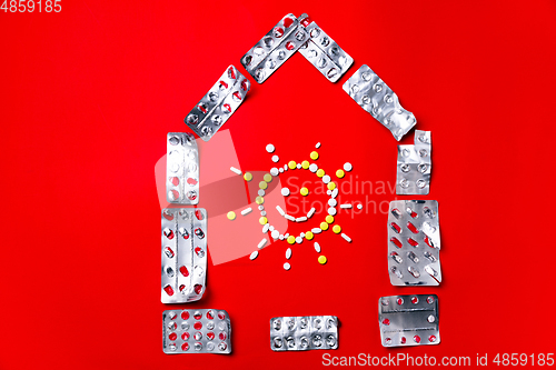 Image of Colored pills, tablets and capsules on a red background - history of treatment, prevention of pandemic