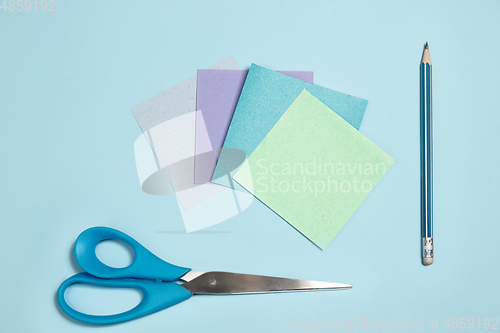 Image of Sticker papers, scissors, pen. Monochrome stylish composition in blue color. Top view, flat lay.