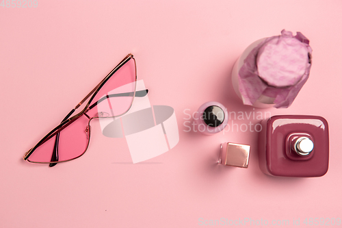 Image of Cosmetics, fashion. Monochrome stylish composition in pink color. Top view, flat lay.