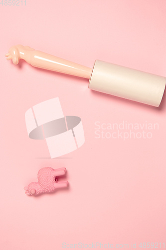 Image of Wear roller and toy. Monochrome stylish composition in pink color. Top view, flat lay.