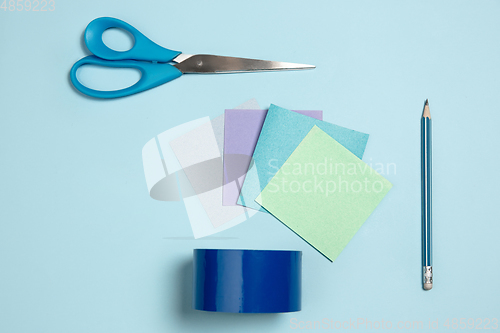 Image of Sticker papers, scissors, pen. Monochrome stylish composition in blue color. Top view, flat lay.