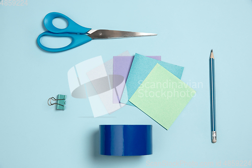 Image of Sticker papers, scissors, pen. Monochrome stylish composition in blue color. Top view, flat lay.