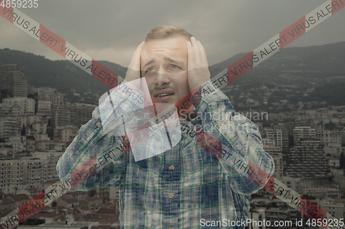 Image of Stressed man holding head with hands on abstract city background. Double exposure. Virus alert, coronavirus pandemic.