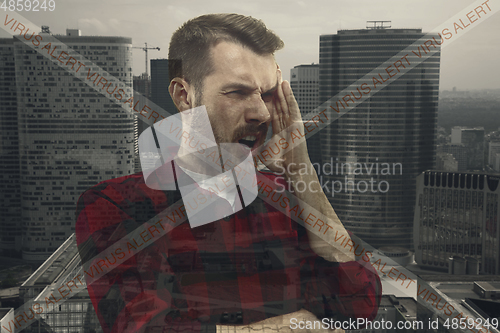 Image of Stressed man holding head with hands on abstract city background. Double exposure. Virus alert, coronavirus pandemic.