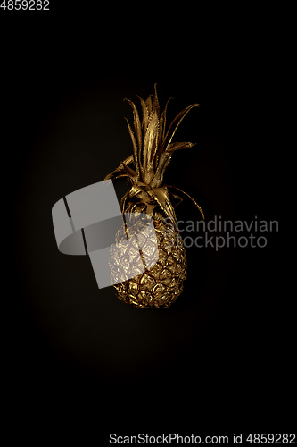 Image of Golden pineapple on a black background, stylish minimalistic composition with copyspace