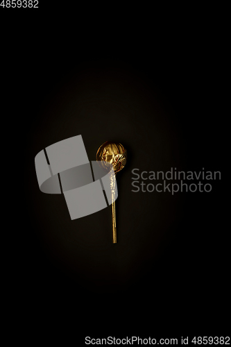 Image of Golden candy on a black background, stylish minimalistic composition with copyspace