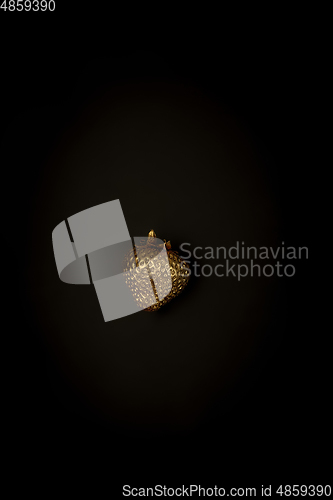 Image of Golden strawberry on a black background, stylish minimalistic composition with copyspace