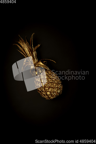 Image of Golden pineapple on a black background, stylish minimalistic composition with copyspace