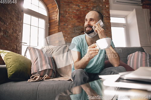 Image of Young man doing yoga at home while being quarantine and freelance working