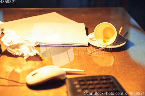 Image of Office workplace, table of latenight deadlined worker with a mess of coffee cups and papers