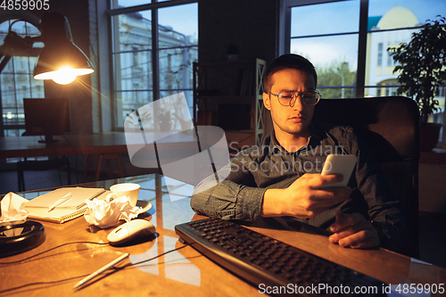 Image of Man working in office alone during coronavirus or COVID-19 quarantine, staying to late night