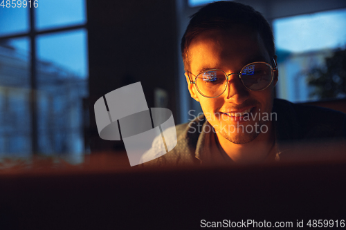 Image of Man working in office alone during coronavirus or COVID-19 quarantine, staying to late night