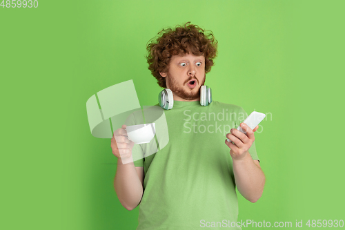 Image of Caucasian young man\'s monochrome portrait on green studio background