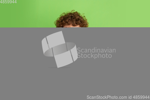 Image of Caucasian young man\'s monochrome portrait on green studio background