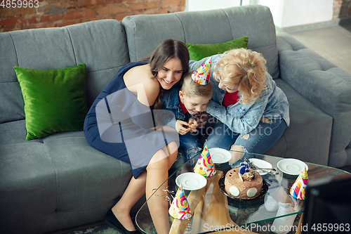 Image of Mother, son and sister at home having fun, comfort and cozy concept, celebrating birthday