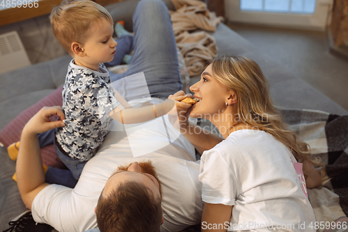 Image of Mother, father and son at home having fun, comfort and cozy concept