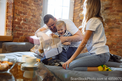 Image of Mother, father and son at home having fun, comfort and cozy concept